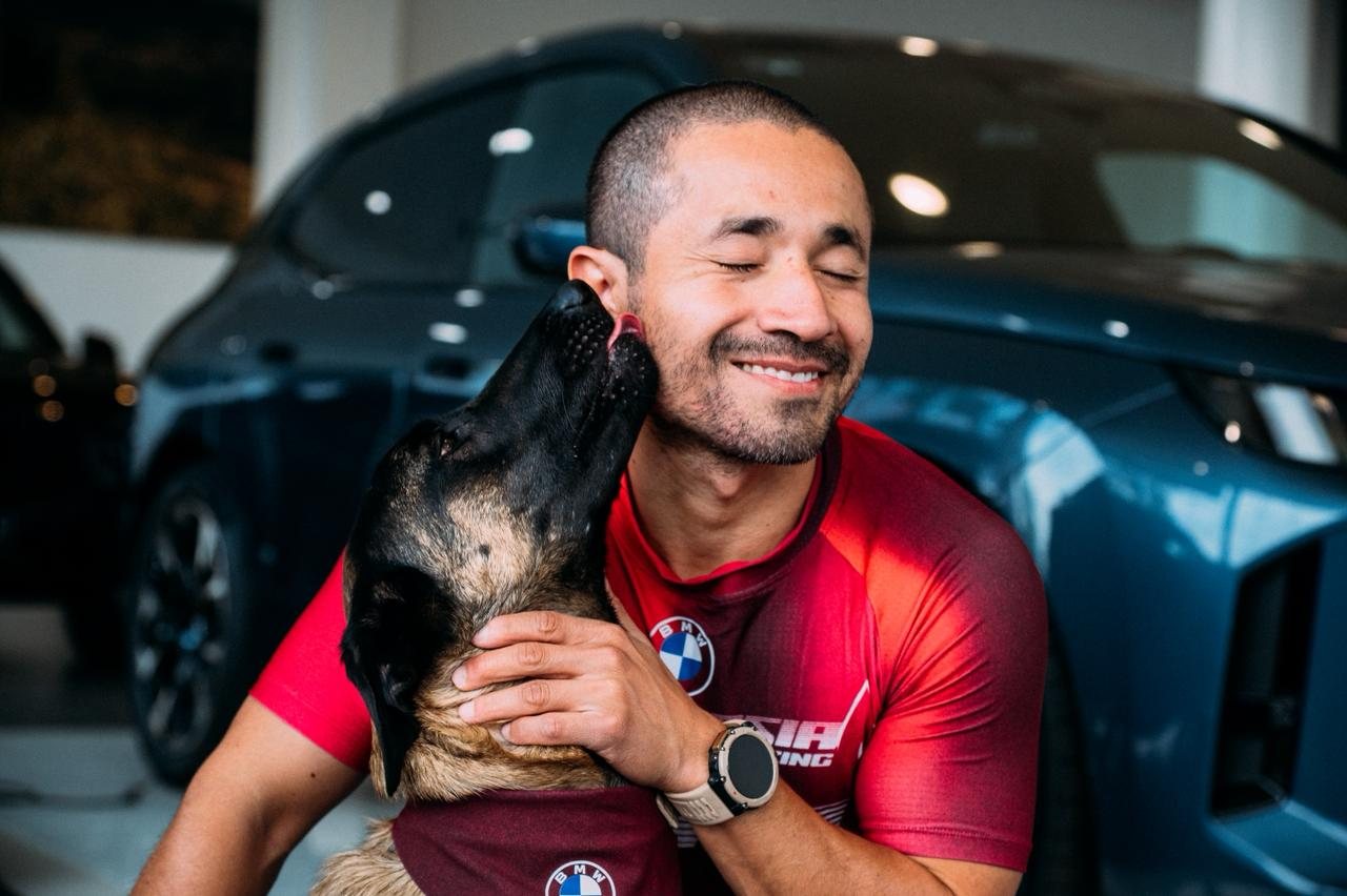 Dante Acevedo cargando en brazos a su perro pastor belga malinois después de entrenar